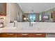 Modern kitchen features a white countertop and undermount sink with views of the living area and balcony at 915 Seaside Dr # 604, Sarasota, FL 34242
