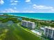 Aerial view of beachfront property with pool and tennis court at 9397 Midnight Pass Rd # 906, Sarasota, FL 34242