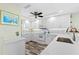 Modern white kitchen with stainless steel appliances and tile backsplash at 9397 Midnight Pass Rd # 906, Sarasota, FL 34242