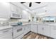 White kitchen with stainless steel appliances and tile backsplash at 9397 Midnight Pass Rd # 906, Sarasota, FL 34242