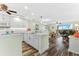 Modern white kitchen with stainless steel appliances and breakfast bar at 9397 Midnight Pass Rd # 906, Sarasota, FL 34242