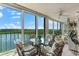 Bright sunroom with glass-top table and chairs at 9397 Midnight Pass Rd # 906, Sarasota, FL 34242