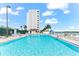 Refreshing swimming pool with surrounding lounge chairs and building in background at 9397 Midnight Pass Rd # 906, Sarasota, FL 34242