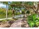 Brick pathway through lush landscaping towards the water at 9397 Midnight Pass Rd # 906, Sarasota, FL 34242