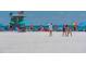 White sand beach with people relaxing under colorful umbrellas at 1887 Rita St, Sarasota, FL 34231