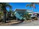 Mobile home with teal exterior and tropical landscaping at 10315 Cortez W Rd # 47-2, Bradenton, FL 34210