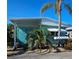 Quaint teal mobile home with palm trees, located in a tropical setting at 10315 Cortez W Rd # 47-2, Bradenton, FL 34210