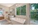 Elegant bathroom with a soaking tub, walk-in shower, and private access to backyard at 1103 Citrus Ave, Sarasota, FL 34236