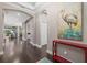 Bright entryway with hardwood floors, red console table, and large artwork at 12606 Fontana Loop, Bradenton, FL 34211