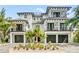 Stunning two-story home with a white exterior, dark trim, and a three-car garage at 129 Mckinley Dr, Sarasota, FL 34236