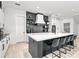 Modern kitchen with white cabinets, black island, and floating shelves at 129 Mckinley Dr, Sarasota, FL 34236