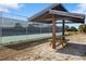 Wooden picnic shelter near tennis courts offers shade and seating at 1488 Ringtail Rd, Venice, FL 34293