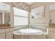 Spa-like bathroom with a circular tub and window seat at 24160 Gallberry Dr, Venice, FL 34293