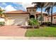 Single-story home with a tile roof, two-car garage, and landscaped yard at 24160 Gallberry Dr, Venice, FL 34293