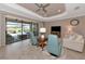 Living room with a white couch, two blue armchairs, and sliding doors to a patio at 24160 Gallberry Dr, Venice, FL 34293