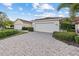 Villa with white garage door, brick paver driveway, and manicured hedges at 3841 Albacete Cir # 51, Punta Gorda, FL 33950