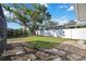 Large backyard with grassy area, mature tree, and stone pathway at 4661 Alexander Pope Ln, Sarasota, FL 34241