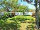 Grassy backyard with mature landscaping and a white fence at 5115 44Th St W, Bradenton, FL 34210