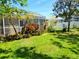 Landscaped backyard featuring a screened patio with lush green lawn at 5115 44Th St W, Bradenton, FL 34210