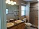 Bathroom with double sink vanity, granite countertop, and a tiled accessible shower at 5115 44Th St W, Bradenton, FL 34210