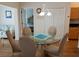 Cozy dining area with a glass table, seating for four, and views into both the living room and an adjacent bedroom at 5115 44Th St W, Bradenton, FL 34210