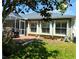 Exterior of home featuring a grill on the patio, with three windows, and a large backyard at 5115 44Th St W, Bradenton, FL 34210