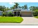Inviting single-story home features a well-manicured lawn, mature landscaping, and a brick-paved driveway leading to a two-car garage at 5115 44Th St W, Bradenton, FL 34210