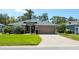 Inviting single-story home features a well-manicured lawn, mature landscaping, and a brick-paved driveway leading to a two-car garage at 5115 44Th St W, Bradenton, FL 34210
