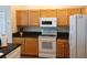 Efficient kitchen featuring light wood cabinets, black countertops, white appliances, and a functional layout for cooking ease at 5115 44Th St W, Bradenton, FL 34210