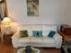 White leather sofa with pillows, end table, and lamp at 5115 44Th St W, Bradenton, FL 34210