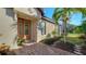 Elegant front door with glass panels, complemented by a brick walkway and lush landscaping at 5846 Cavano Dr, Sarasota, FL 34231