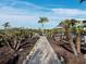 A stone pathway leads through a lush backyard garden to a waterfront property at 6161 Gulf Of Mexico Dr, Longboat Key, FL 34228