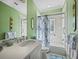 Bathroom with green wallpaper, shower and tub, and a white vanity at 6161 Gulf Of Mexico Dr, Longboat Key, FL 34228