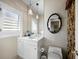 Powder room showcasing white cabinets, framed mirror, and decorative lighting, offering a blend of style and functionality at 6161 Gulf Of Mexico Dr, Longboat Key, FL 34228