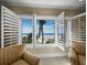 Beautiful beach views from a light-filled living space with plush seating and open plantation shutters at 6161 Gulf Of Mexico Dr, Longboat Key, FL 34228