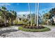 Circular driveway leading to a charming yellow home, surrounded by palm trees and well-manicured landscaping at 6161 Gulf Of Mexico Dr, Longboat Key, FL 34228