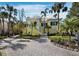 Charming two-story yellow home with a well-maintained paver driveway and lush tropical landscaping at 6161 Gulf Of Mexico Dr, Longboat Key, FL 34228