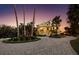 Home's exterior and circular driveway, enhanced by manicured landscaping and towering palm trees at sunset at 6161 Gulf Of Mexico Dr, Longboat Key, FL 34228