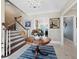 Inviting foyer with a wooden staircase, chandelier, and decorative table with floral arrangement at 6161 Gulf Of Mexico Dr, Longboat Key, FL 34228