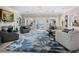 Spacious living room with elegant furnishings, chandelier, and French doors leading to a balcony with ocean views at 6161 Gulf Of Mexico Dr, Longboat Key, FL 34228