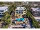 Aerial view of a yellow two-story home showcasing a swimming pool, lounge chairs, and tropical landscaping at 6161 Gulf Of Mexico Dr, Longboat Key, FL 34228