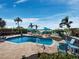 A backyard pool surrounded by lounge chairs, umbrellas, and lush landscaping near the waterfront at 6161 Gulf Of Mexico Dr, Longboat Key, FL 34228