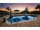 Enjoy relaxing poolside with palm trees and a colorful sunset casting a warm glow on a beautiful pool at 6161 Gulf Of Mexico Dr, Longboat Key, FL 34228