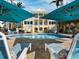 A beautiful backyard pool with lounge chairs and umbrellas at a luxury waterfront property at 6161 Gulf Of Mexico Dr, Longboat Key, FL 34228