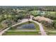 Aerial view of luxury home with pond and circular driveway at 6200 Saddle Oak Trl, Sarasota, FL 34241