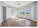 Sunlit bedroom featuring wood floors and three large windows at 6200 Saddle Oak Trl, Sarasota, FL 34241