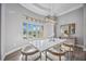 Elegant dining room with bay window, chandelier, and modern table setting at 6200 Saddle Oak Trl, Sarasota, FL 34241