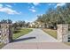 Elegant home with a long paved driveway and stone pillars at 6200 Saddle Oak Trl, Sarasota, FL 34241