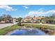 Luxury home with pond and landscaping in front at 6200 Saddle Oak Trl, Sarasota, FL 34241
