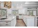White kitchen with marble countertops, large island, and ample cabinet space at 6200 Saddle Oak Trl, Sarasota, FL 34241
